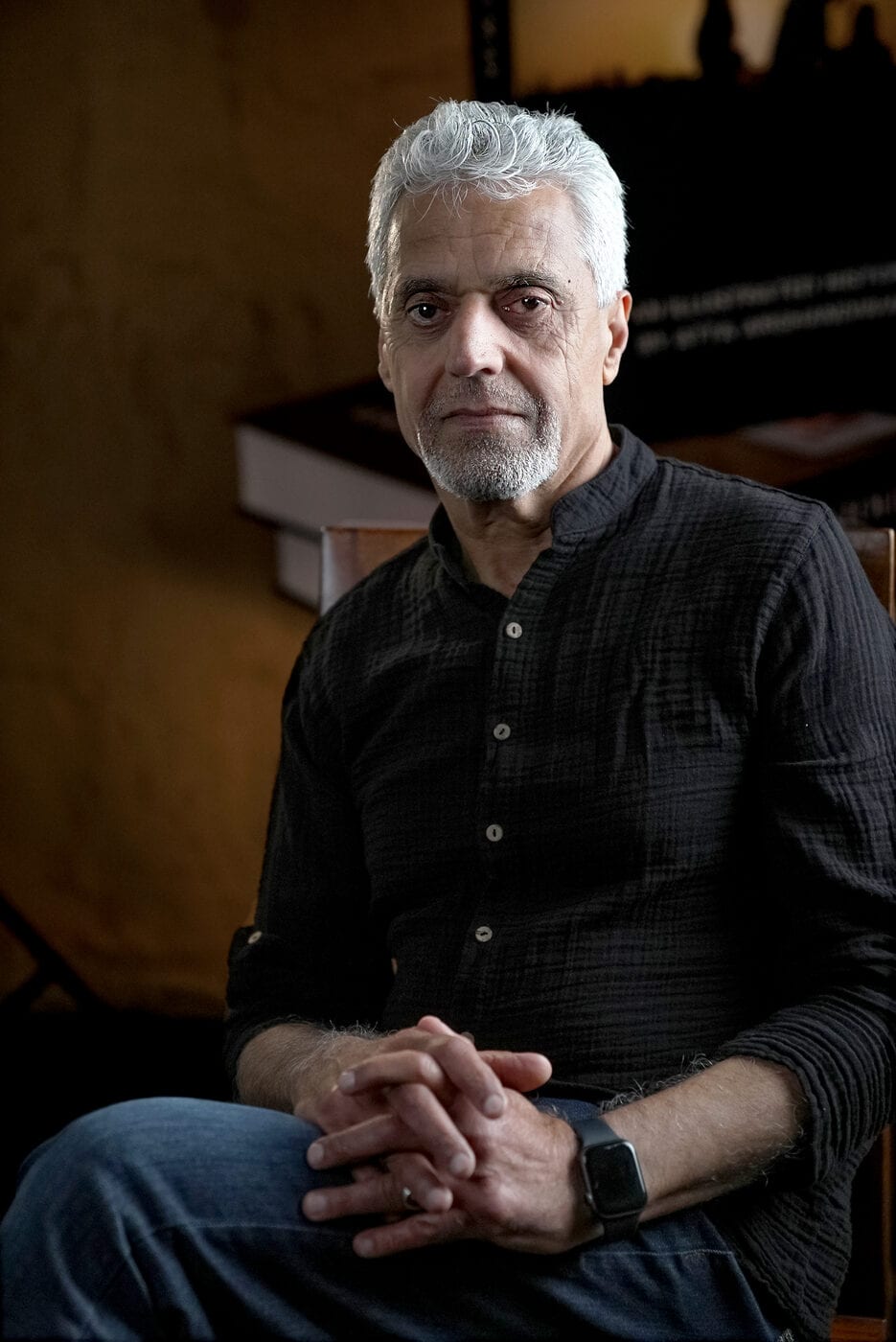 Atta Arghandiwal seated in a dark shirt in warm, low light.